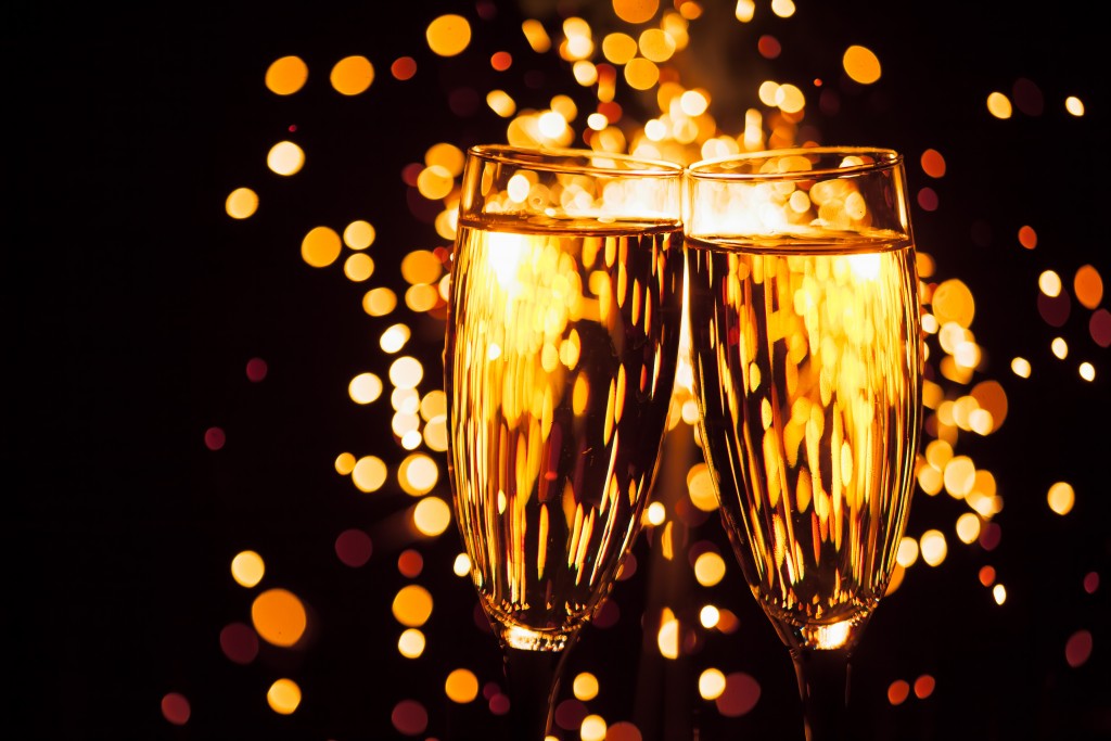 champagne glass against christmas sparkler background